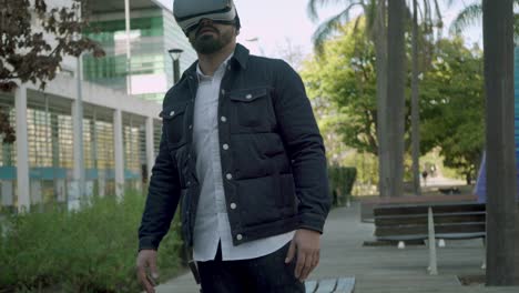 Man-gesturing-and-using-vr-glasses-on-street